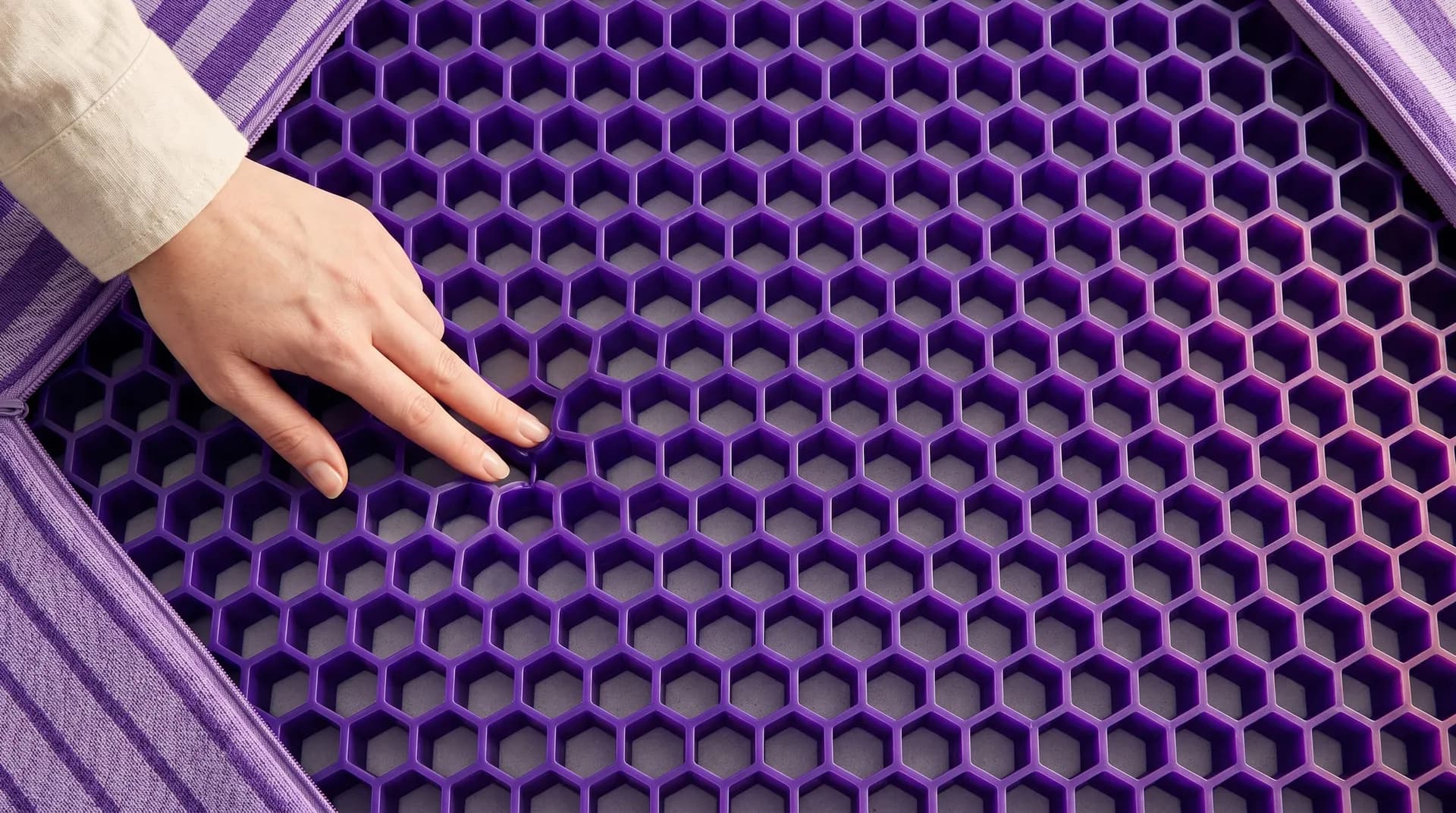 Hand pressing into the purple hexagonal GelFlex grid of the Purple Original